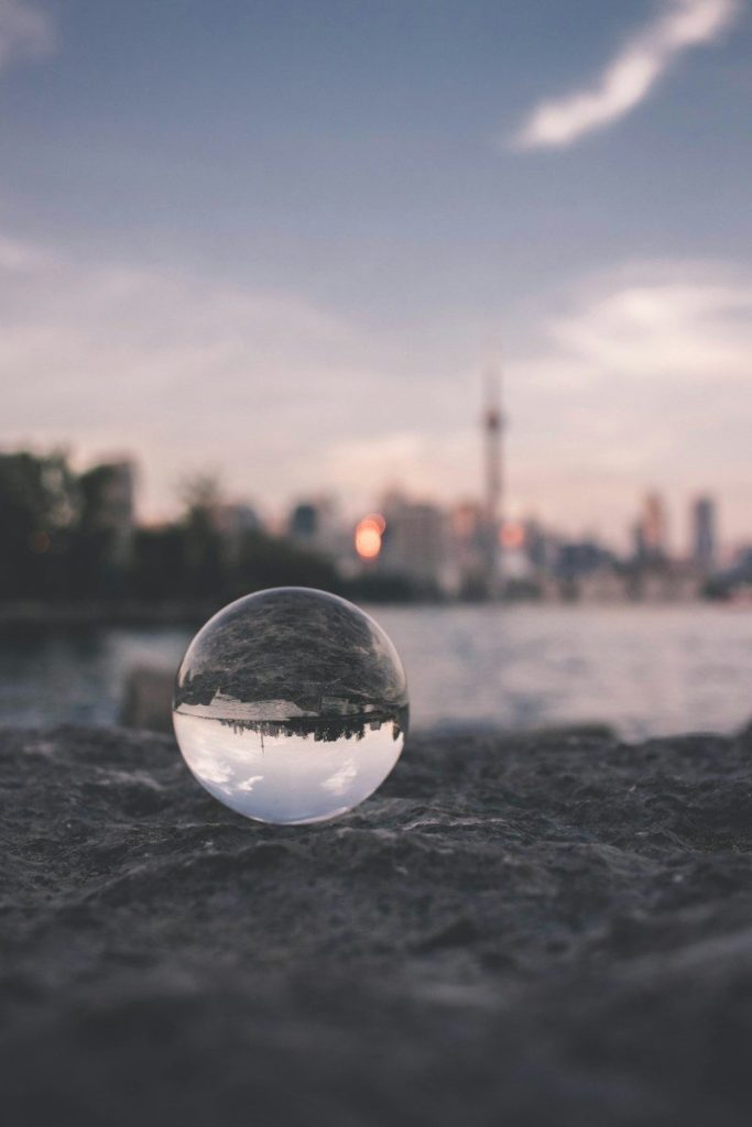 selective focus photography of glass ball on sandy ground